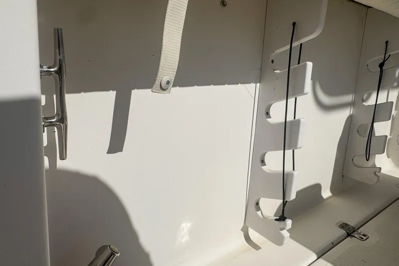 Slide: The Image of Interior view of a 2005 Pro-Line 24 Sport boat, featuring rod holders and cleat. - 83