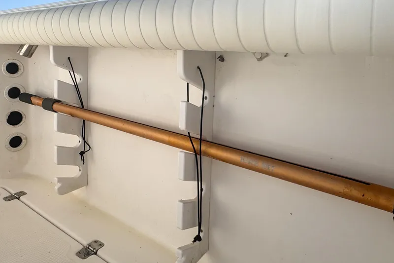 Slide: The Image of 2005 Pro-Line 24 Sport boat interior with rod holder and cushioned side panel. - 87