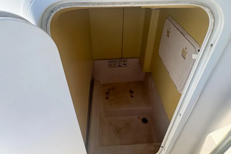 Slide: The Image of 2005 Pro-Line 24 Sport boat storage compartment, open hatch, interior view. - 92