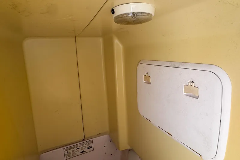 Slide: The Image of 2005 Pro-Line 24 Sport boat interior with storage compartment and ceiling light. - 93