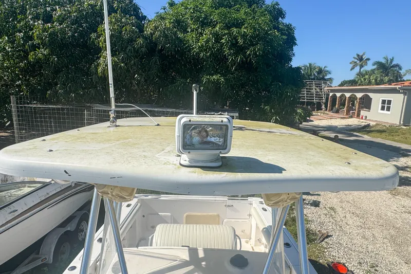 Slide: The Image of 2005 Pro-Line 24 Sport boat with spotlight on top, surrounded by trees and buildings. - 96