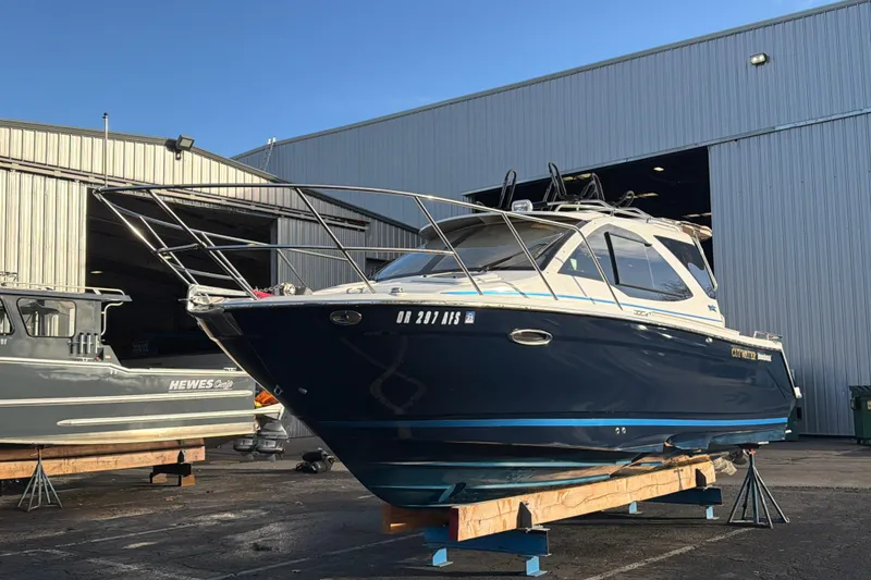 The Image of 2016 Cutwater C-242 Coupe boat on stands outside a large warehouse. - 0