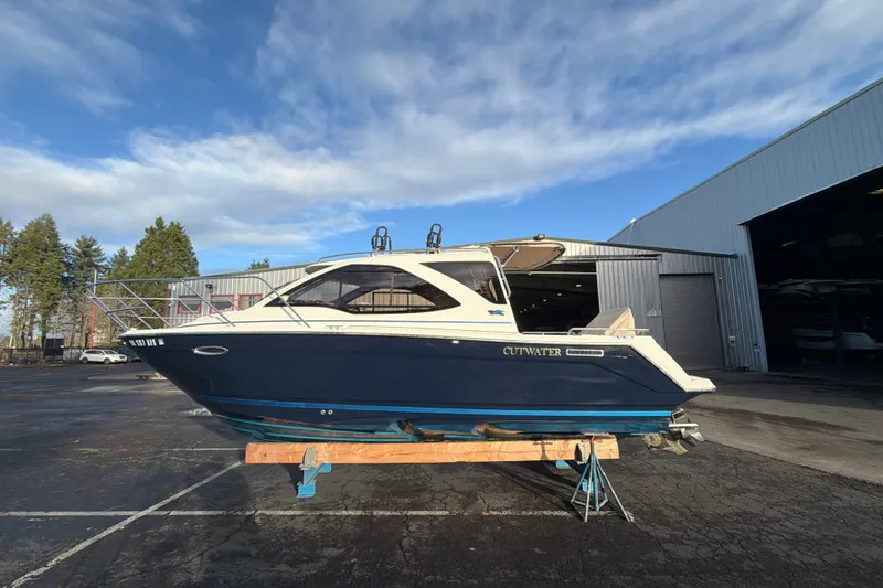 Slide: The Image of 2016 Cutwater C-242 Coupe boat on a stand, outdoors near a warehouse. - 11