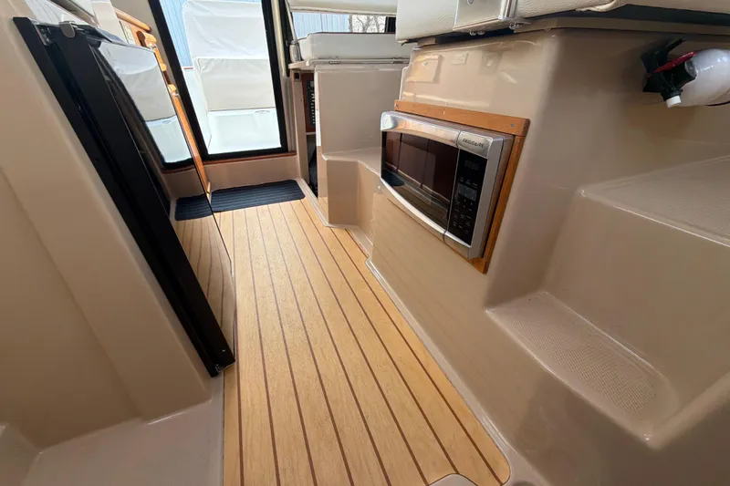 Slide: The Image of 2016 Cutwater C-242 Coupe interior with wood flooring and built-in microwave. - 33