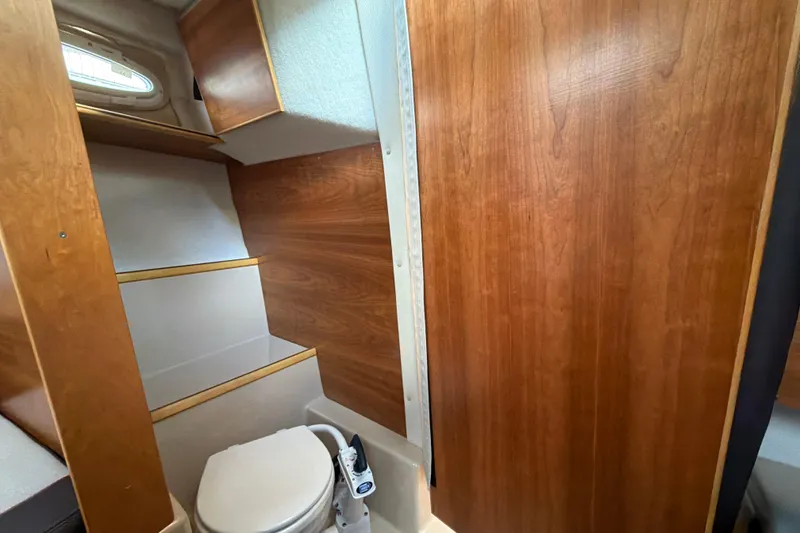 Slide: The Image of 2016 Cutwater C-242 Coupe interior bathroom with wooden cabinetry and compact toilet. - 40