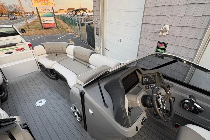 Slide: The Image of 2023 Avalon Excalibur 2585 Windshield Elite boat interior with steering console and seating. - 15