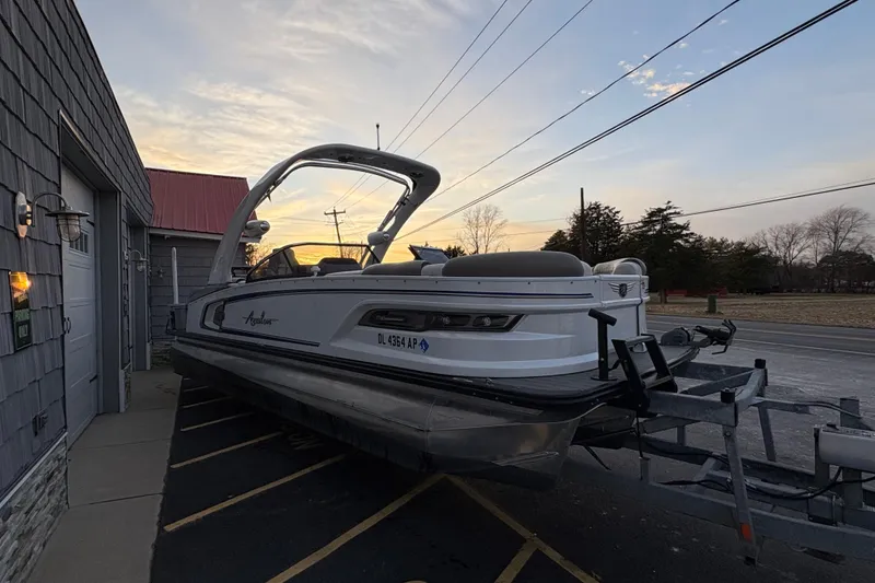 Slide: The Image of 2023 Avalon Excalibur 2585 Windshield Elite Tri Toon boat on trailer at sunset. - 6