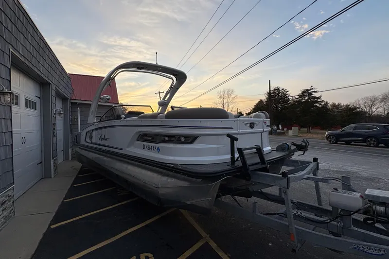 Slide: The Image of 2023 Avalon Excalibur 2585 Windshield Elite Tri Toon on trailer at sunset. - 7