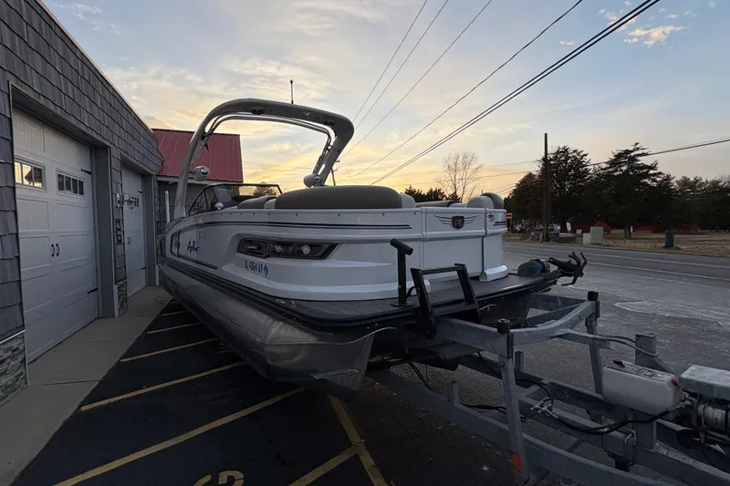 Slide: The Image of 2023 Avalon Excalibur 2585 Windshield Elite Tri Toon on trailer at sunset. - 8