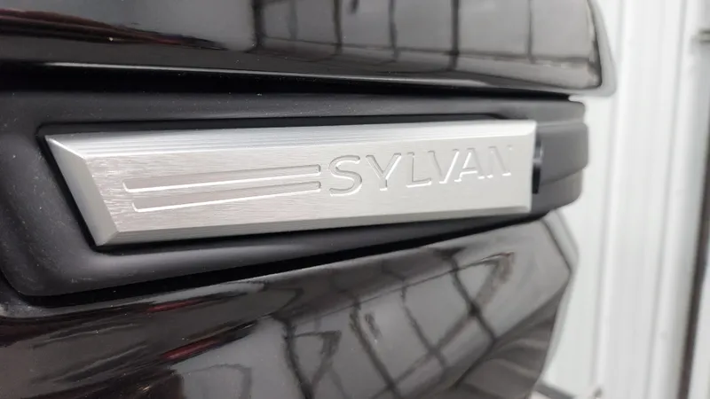 Slide: The Image of Close-up of the Sylvan logo on a dark background. - 44