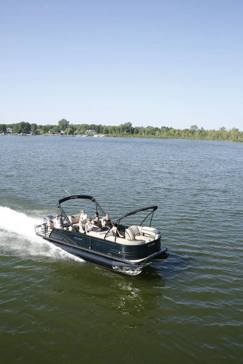 Slide: The Image of 2026 Sylvan L-3 RLZ pontoon boat cruising on a calm lake. - 3