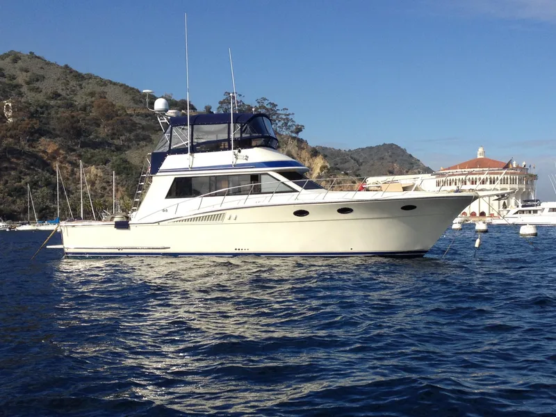The Image of 1987 Californian 48 Convertible yacht anchored near a scenic coastline. - 0