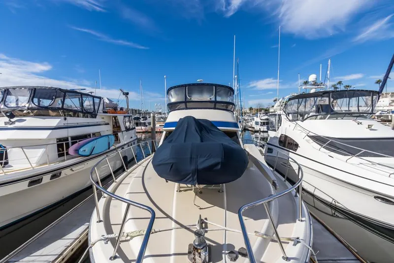 Slide: The Image of 1987 Californian 48 Convertible yacht docked at a marina under a clear blue sky. - 13