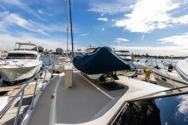 Slide: The Image of 1987 Californian 48 Convertible yacht docked at a marina under a blue sky. - 16