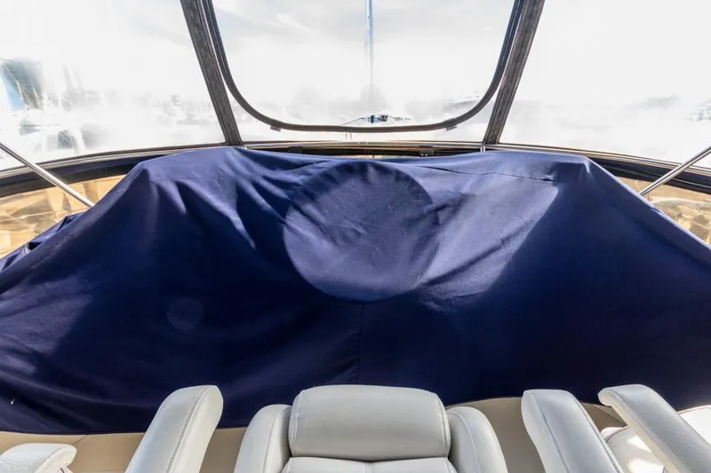 Slide: The Image of 1987 Californian 48 Convertible yacht interior with covered dashboard and white seats. - 19