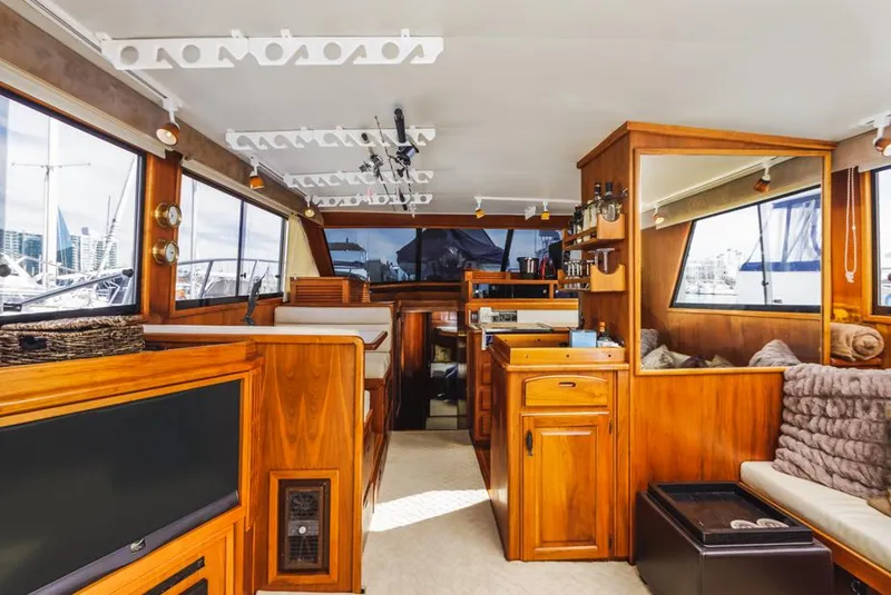 Slide: The Image of Interior of a 1987 Californian 48 Convertible yacht with wooden furnishings and large windows. - 30