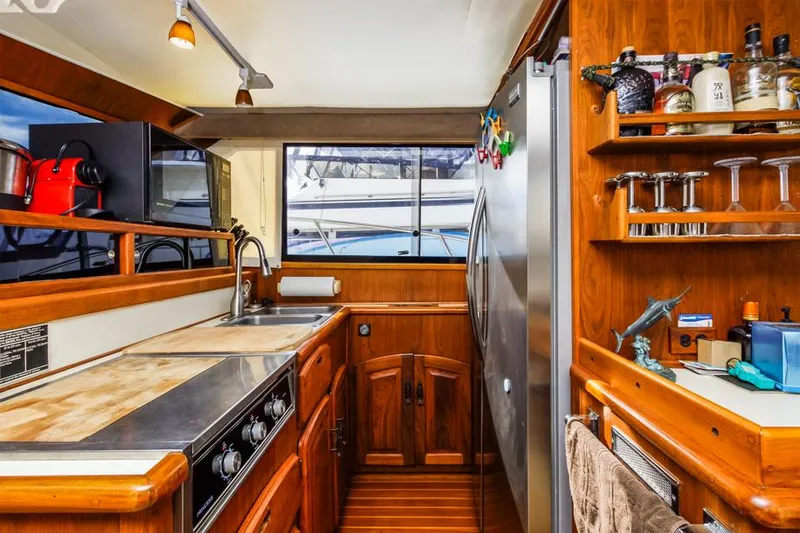 Slide: The Image of 1987 Californian 48 Convertible yacht kitchen with wooden cabinetry, stainless steel appliances, and ample storage. - 37
