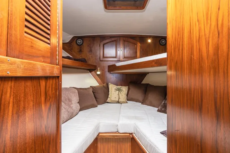 Slide: The Image of 1987 Californian 48 Convertible boat cabin with wooden interior and cozy bedding. - 46