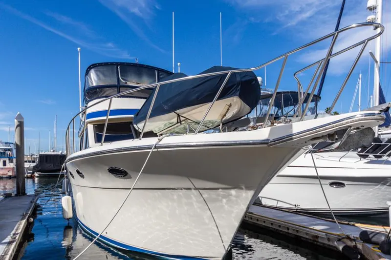 Slide: The Image of 1987 Californian 48 Convertible yacht docked at marina under clear blue sky. - 6