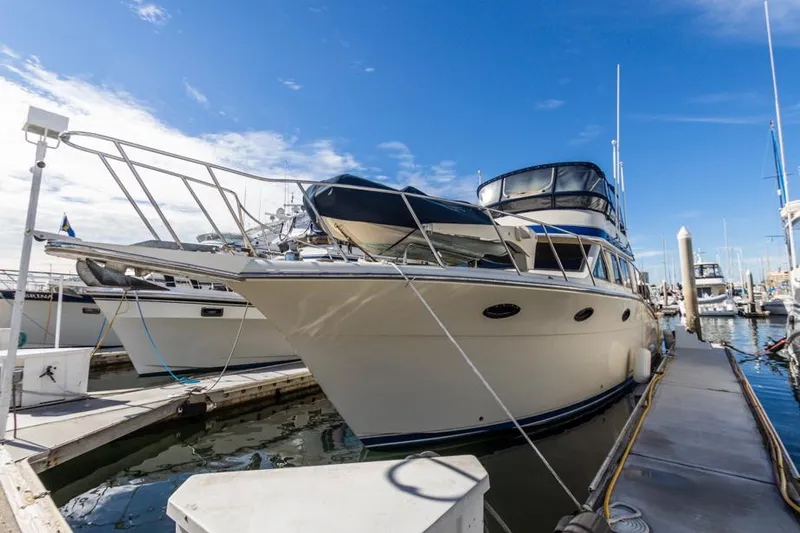Slide: The Image of 1987 Californian 48 Convertible yacht docked at marina under clear blue sky. - 8