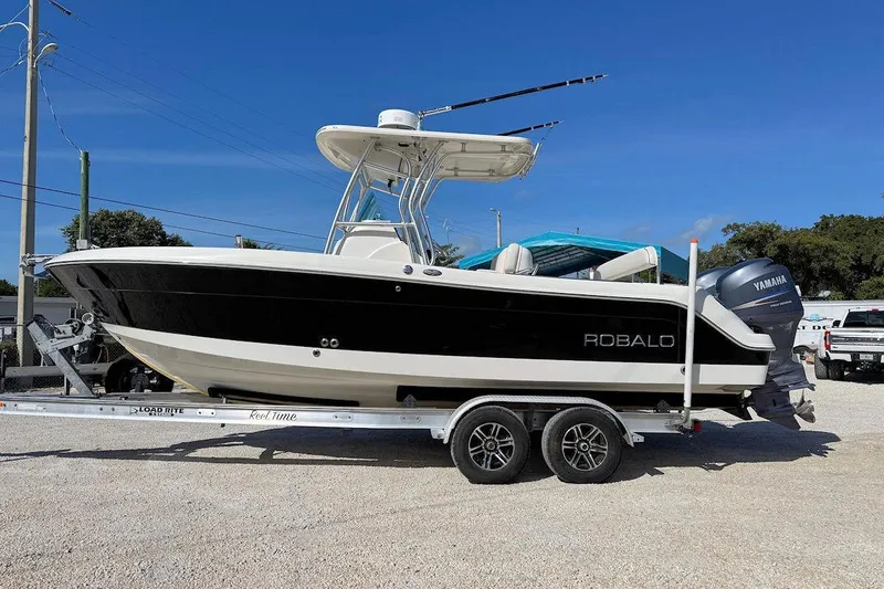 Slide: The Image of 2007 Robalo R240 Center Console boat on trailer, featuring Yamaha engine, under clear blue sky. - 4