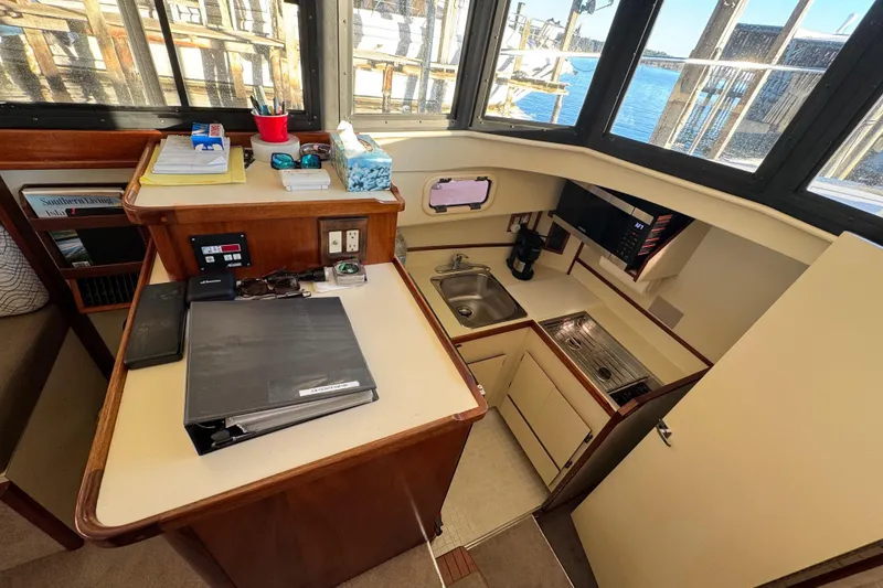 Slide: The Image of Interior of 2002 Camano Troll 31 boat with seating, table, and helm station. - 21