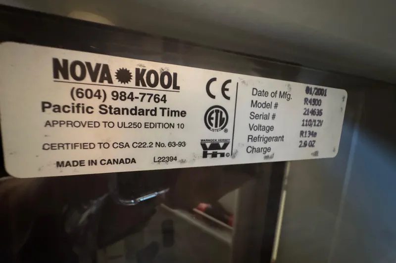 Slide: The Image of 2002 Camano Troller interior with compact fridge and countertop essentials. - 40