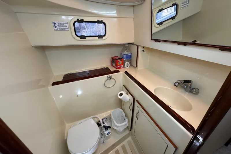 Slide: The Image of Interior of a 2002 Camano Troller boat, featuring a compact kitchen and dining area. - 47
