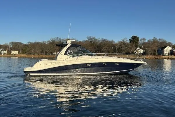 Slide: The Image of 2003 Sea Ray 420 Sundancer yacht cruising on calm waters under clear blue skies. - 1