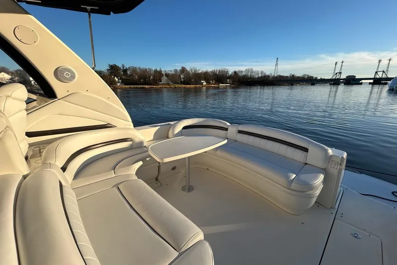 Slide: The Image of 2003 Sea Ray 420 Sundancer yacht with elegant seating, docked by a serene waterfront. - 2