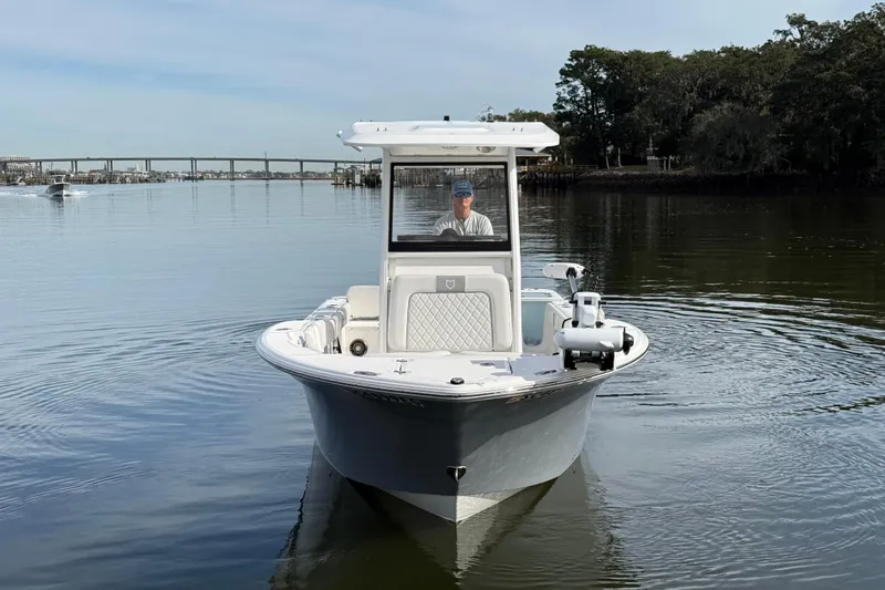 Slide: The Image of 2025 Sea Fox 248 Commander boat on calm water, with bridge in background. - 2