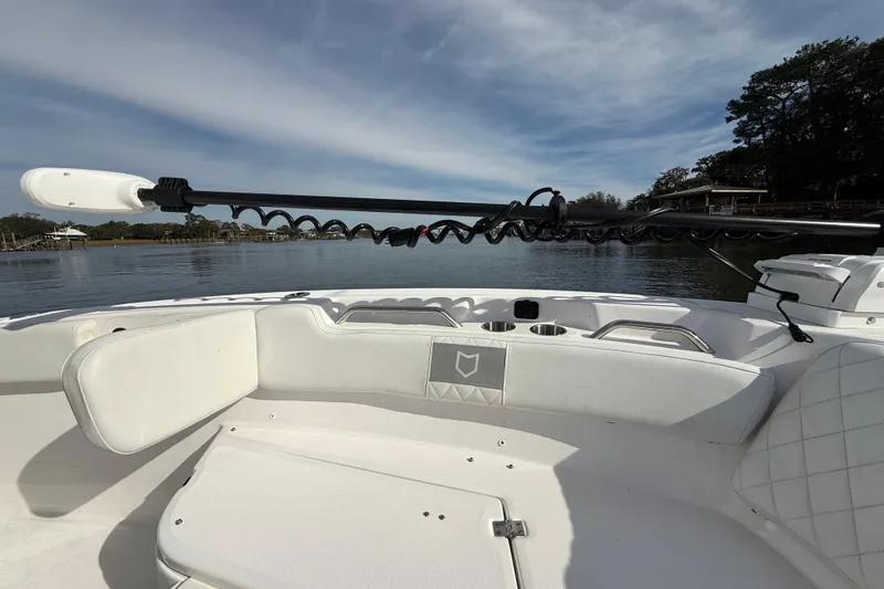 Slide: The Image of 2025 Sea Fox 248 Commander boat interior with seating and fishing rod holder on a calm lake. - 23