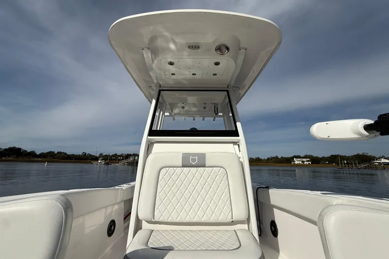 Slide: The Image of 2025 Sea Fox 248 Commander boat interior with seating and console, on calm water. - 26