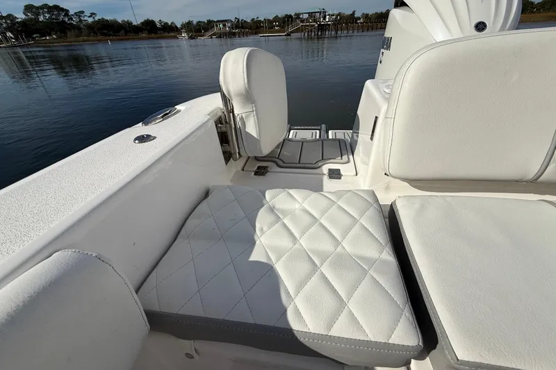 Slide: The Image of 2025 Sea Fox 248 Commander boat with white cushioned seating by the water. - 28