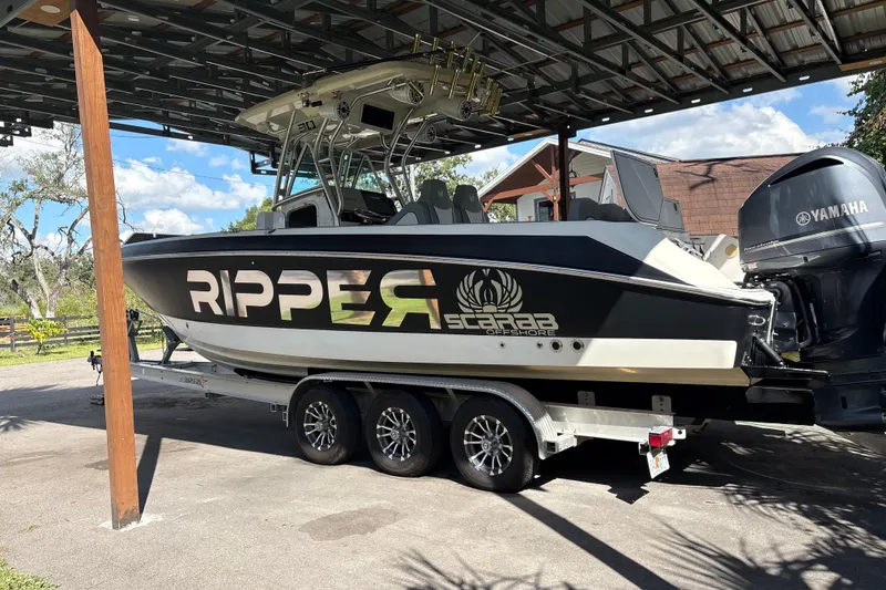 Slide: The Image of 2012 Wellcraft 30 Scarab Offshore Sport boat on trailer under shelter. - 4