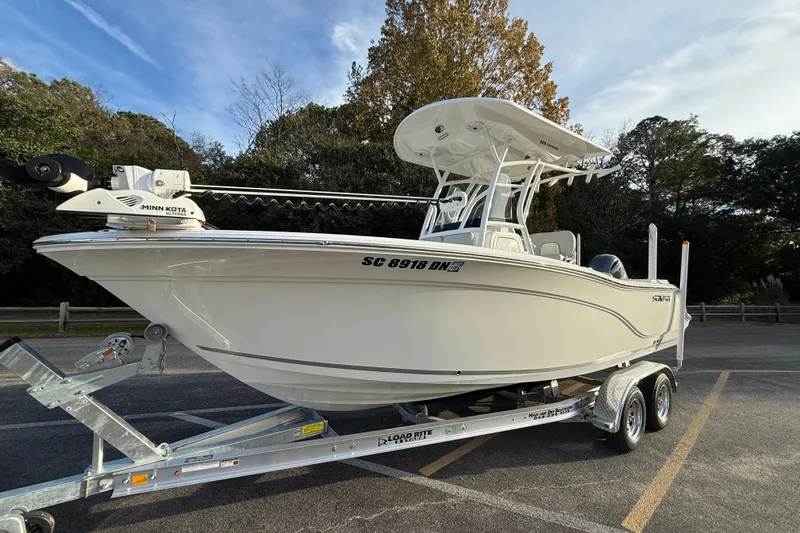 Slide: The Image of 2021 Sea Fox 228 Commander boat on trailer, parked outdoors, with Minn Kota trolling motor. - 6