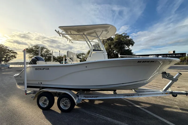 Slide: The Image of 2021 Sea Fox 228 Commander boat on trailer, parked outdoors under a cloudy sky. - 8