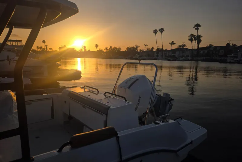 Slide: The Image of Sunset view from a 2024 Beneteau Oceanis 281, with palm trees and calm waters. - 10