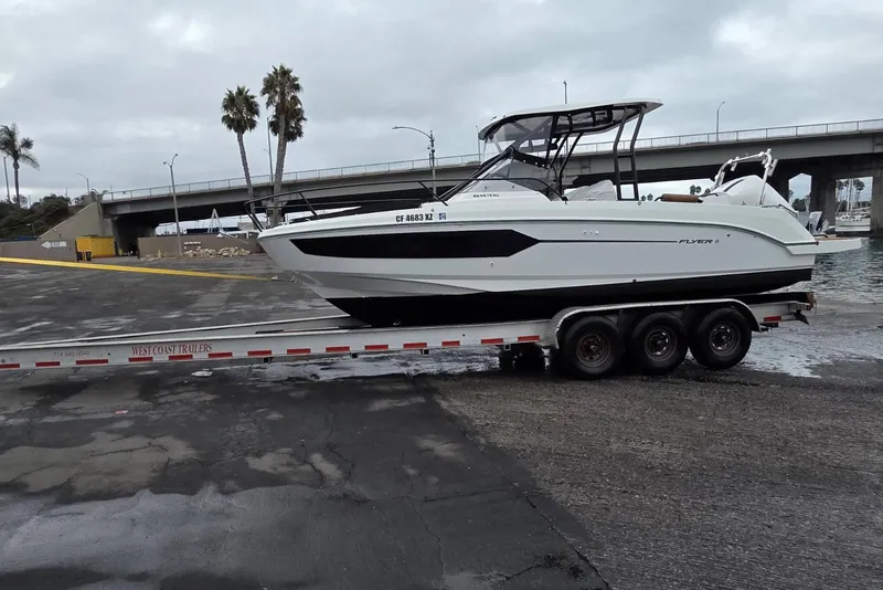 Slide: The Image of 2024 Beneteau Oceanis 281 boat on trailer near waterfront, overcast sky. - 11