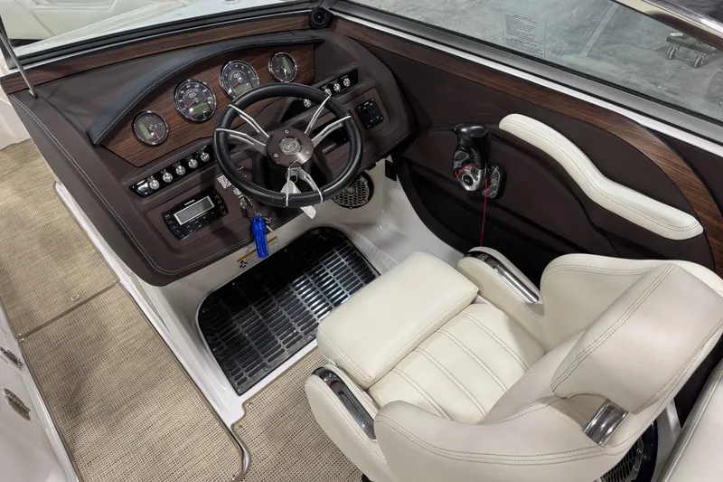 Slide: The Image of 2015 Cobalt R5 boat cockpit with steering wheel, gauges, and beige seating. - 9