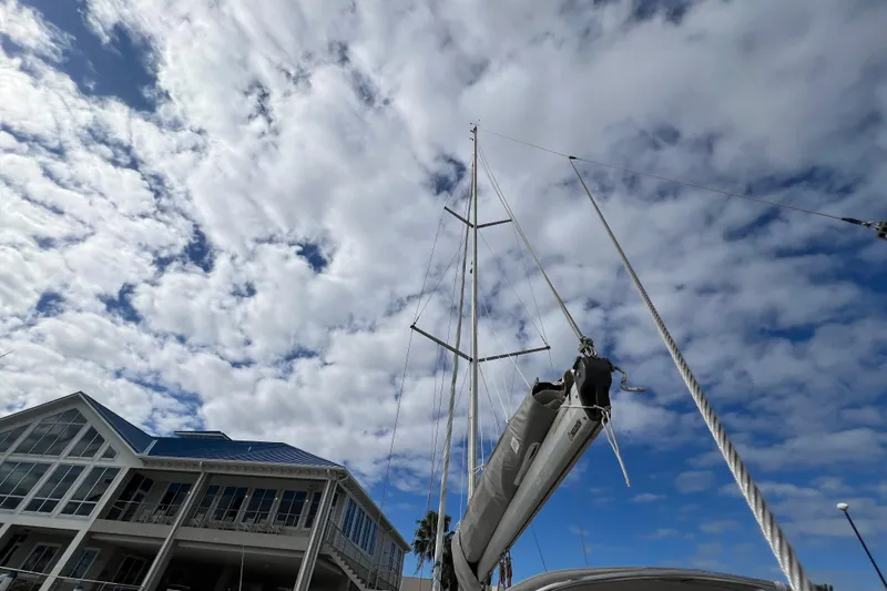 Slide: The Image of Delphia 33 Sloop sailboat mast against cloudy sky, near a modern building, 2007 model. - 17