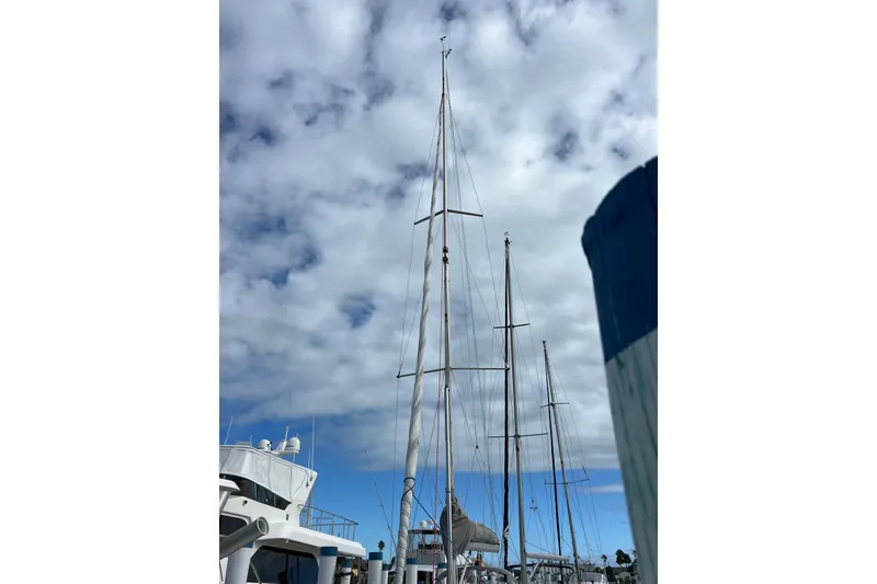 Slide: The Image of Tall masts of a 2007 Delphia 33 Sloop sailboat against a cloudy sky. - 18