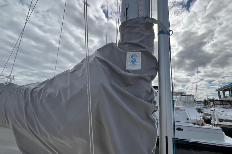 Slide: The Image of Delphia 33 Sloop 2007 with sail cover, docked under cloudy sky. - 21