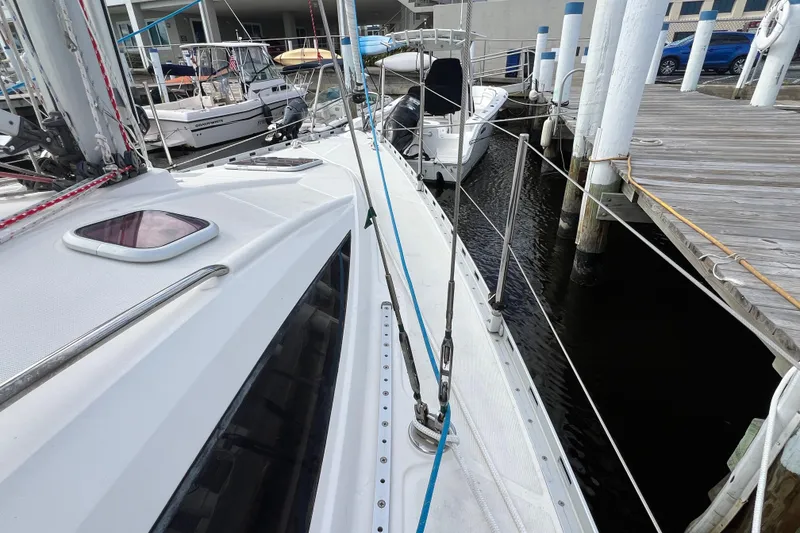 Slide: The Image of 2007 Delphia 33 Sloop docked at marina, showcasing deck and rigging details. - 22