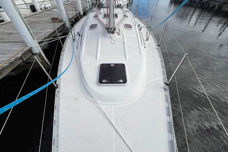 Slide: The Image of 2007 Delphia 33 Sloop docked, showcasing deck and rigging details. - 26