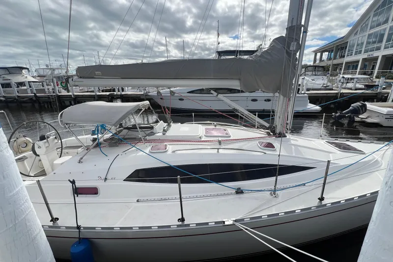 Slide: The Image of 2007 Delphia 33 Sloop docked at marina, featuring sleek design and covered cockpit. - 29