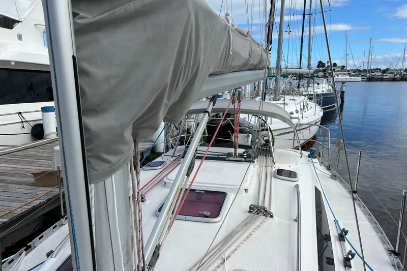 Slide: The Image of 2007 Delphia 33 Sloop docked at marina, showcasing deck and rigging. - 36