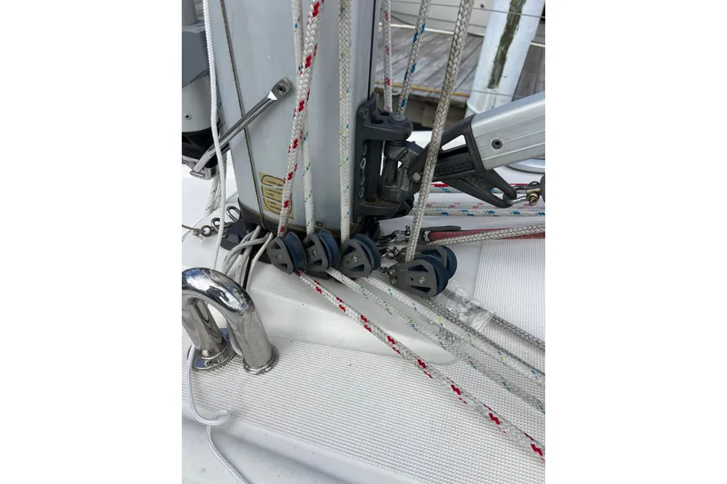 Slide: The Image of Close-up of rigging on a 2007 Delphia 33 Sloop sailboat, featuring ropes and pulleys. - 44