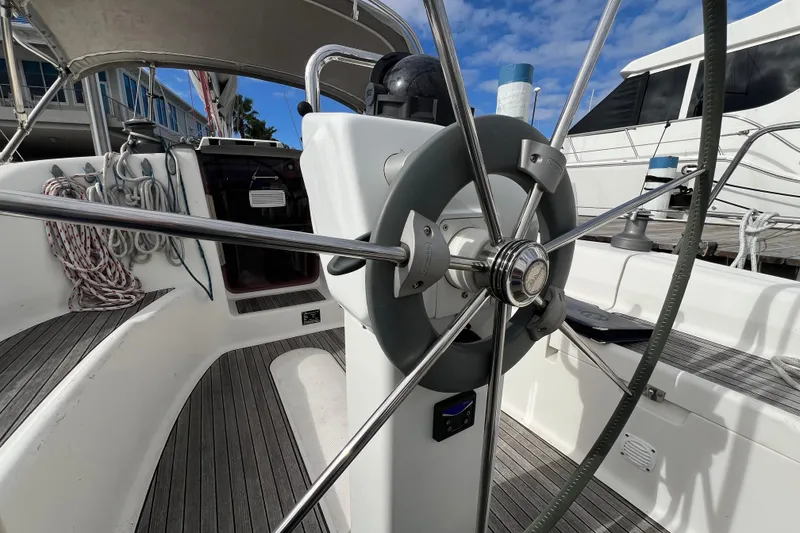 Slide: The Image of Steering wheel of 2007 Delphia 33 Sloop sailboat, docked with ropes and equipment. - 56