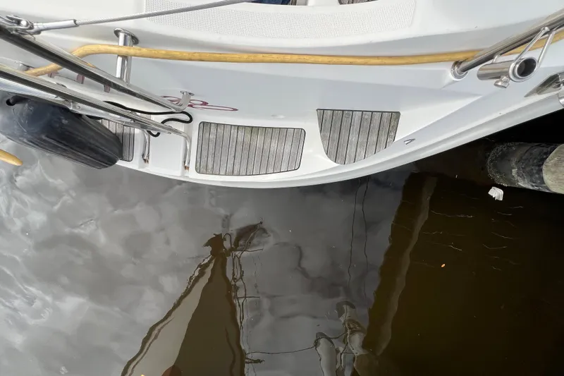 Slide: The Image of 2007 Delphia 33 Sloop stern view with wooden deck and water reflection. - 64